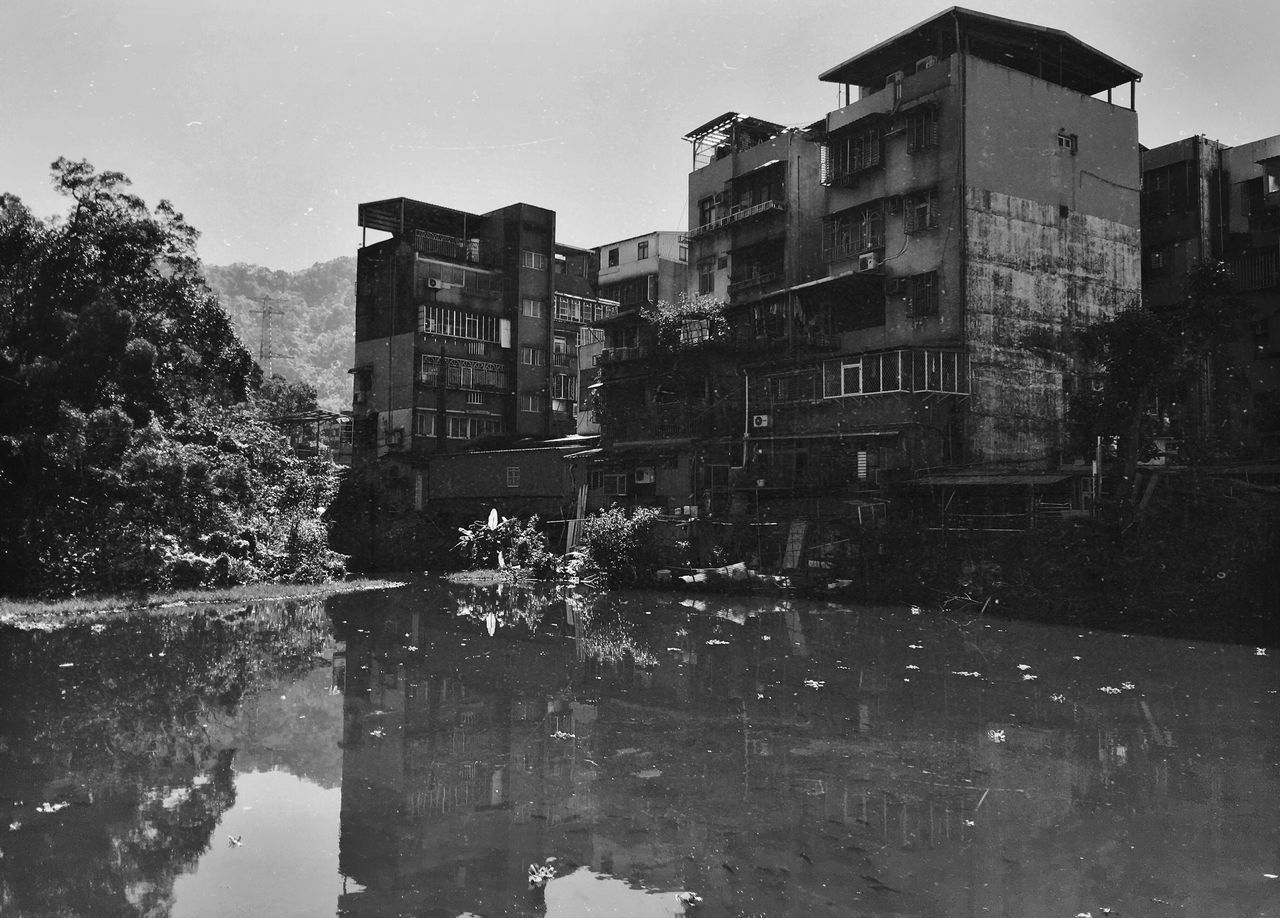 architecture, building exterior, built structure, water, house, tree, clear sky, reflection, residential structure, residential building, sky, building, day, abandoned, outdoors, old, nature, no people, waterfront, damaged