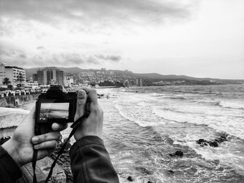 Man photographing with camera against sky