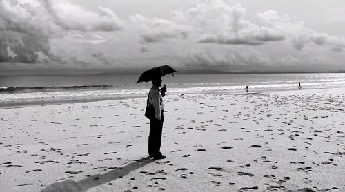 Full length of woman on beach against sky