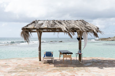 Wooden canopy with palm leaves roof on the beach by the ocean. chair and massage bad for relaxing