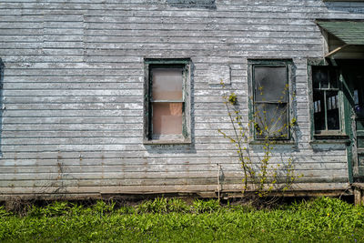 Windows and wall of abandoned and weathered wood house