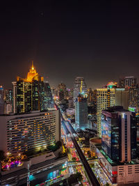 Illuminated buildings in city against sky at night