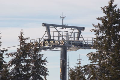 Low angle view of communications tower against sky during winter