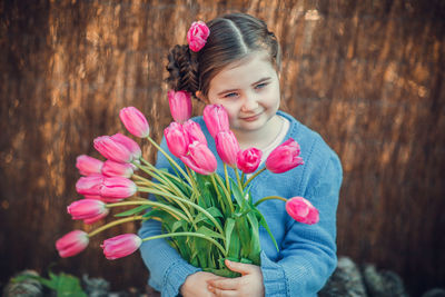 Portrait of girl holding pink flower