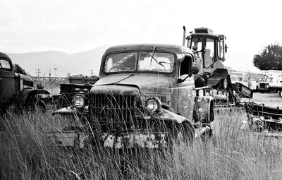 Abandoned truck on field against sky