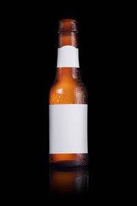 Close-up of glass bottle against black background