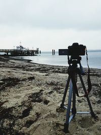 Man photographing at beach against sky