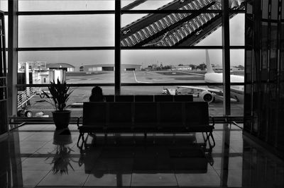 Rear view of people sitting on chair at airport