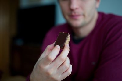 Closeup of man's hand holding chocolate cookie