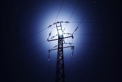 Low angle view of electricity pylon against sky