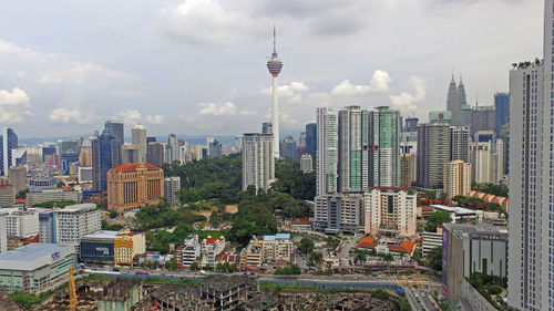 View of cityscape against cloudy sky