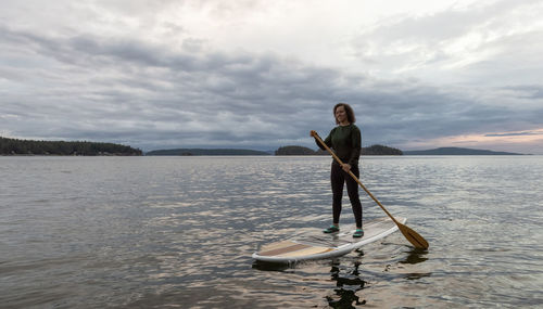 Full length of man standing in sea against sky