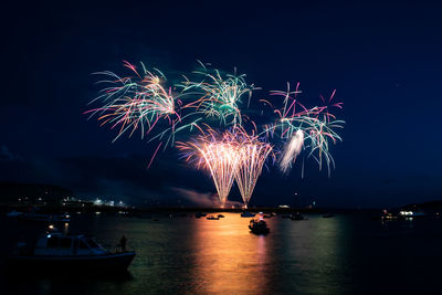 Firework display over sea at night