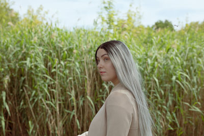 Portrait of beautiful young woman standing on land