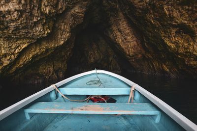 Boat in sea against rock formation