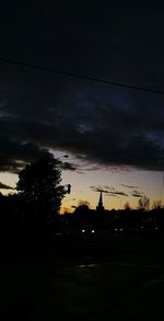 Silhouette of electricity pylon at sunset