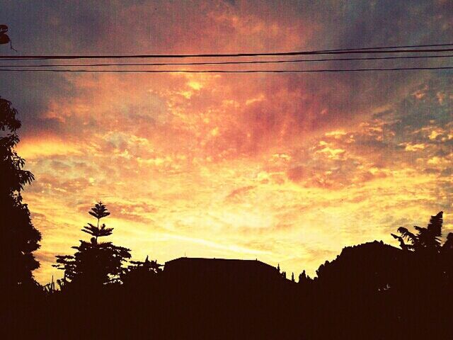 sunset, silhouette, sky, low angle view, building exterior, built structure, tree, architecture, orange color, power line, cloud - sky, house, beauty in nature, nature, scenics, cloud, outdoors, no people, residential structure, tranquility