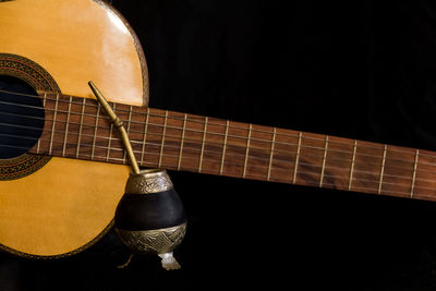 Close-up of guitar against black background