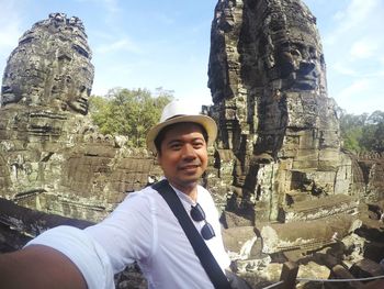 Portrait of young man standing at historic temple