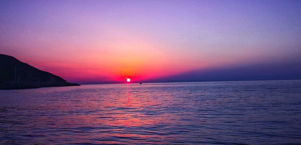 Scenic view of sea against romantic sky at sunset