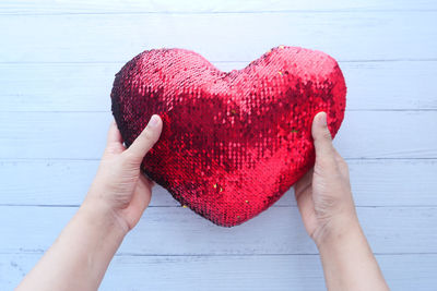 Midsection of woman holding heart shape with hands