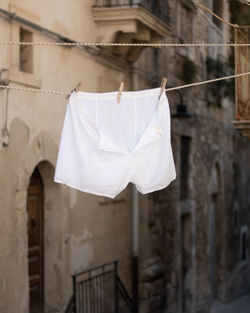 Low angle view of clothes drying on rope against building