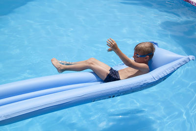 High angle view of boy relaxing in swimming pool