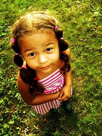 Portrait of cute girl standing on grassy field