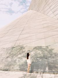 Rear view of woman standing against sky