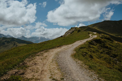 Road amidst green landscape against sky