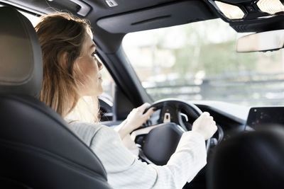 Midsection of woman sitting in car