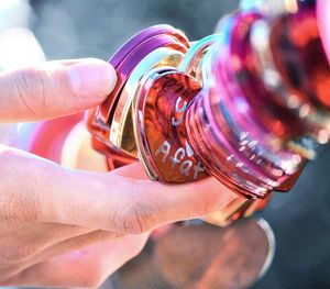 Close-up of person touching padlocks