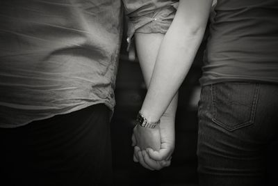 Low section of man and woman holding hands