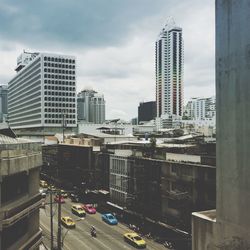 View of city street against cloudy sky