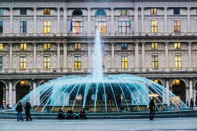 People at fountain in city