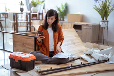 Woman assembling furniture at home