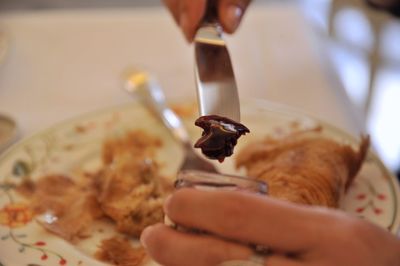 Close-up of hand holding food in plate