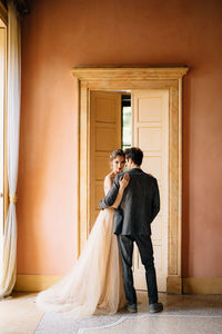 Man and woman standing near door