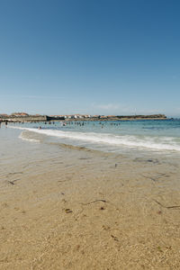 Scenic view of beach against clear blue sky