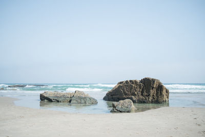 Scenic view of rocks on beach against sky