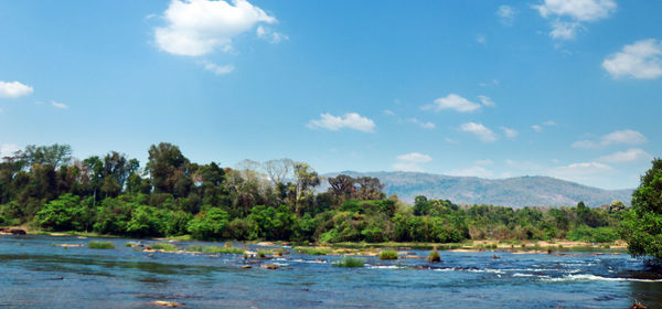 Scenic view of river and mountains against sky