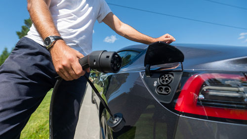 Midsection of man holding car