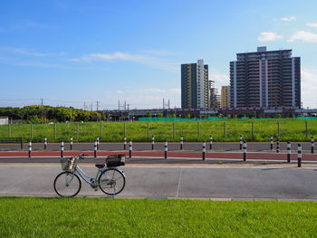 Bicycles on road in city against sky