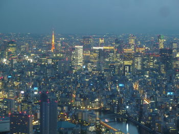 Illuminated cityscape against sky at night