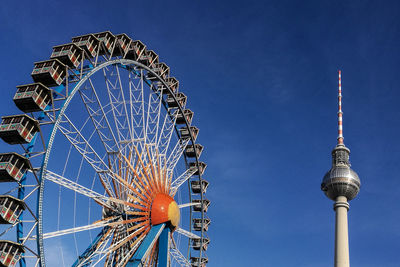 Low angle view of ferris wheel against blue sky