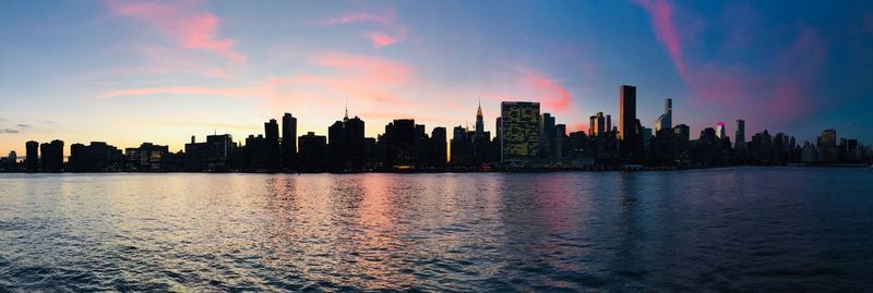 Silhouette buildings by city against sky during sunset