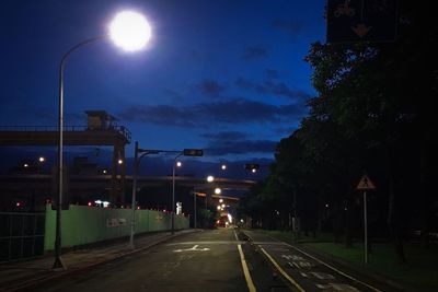 Illuminated railroad tracks against sky at night