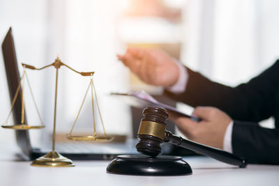 Close-up of hand holding book on table
