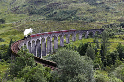 Arch bridge against trees on mountain