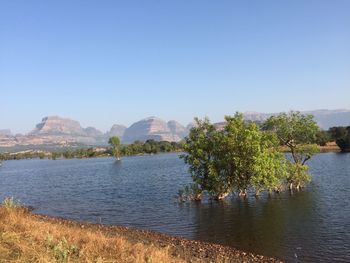 Scenic view of landscape and mountains against clear blue sky